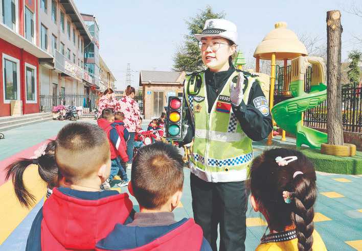 操场上，盐湖民警教孩子们学做交警指挥手势操